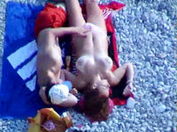 The big titted nudist woman is getting suntanned and rubbed by the guy in boxers